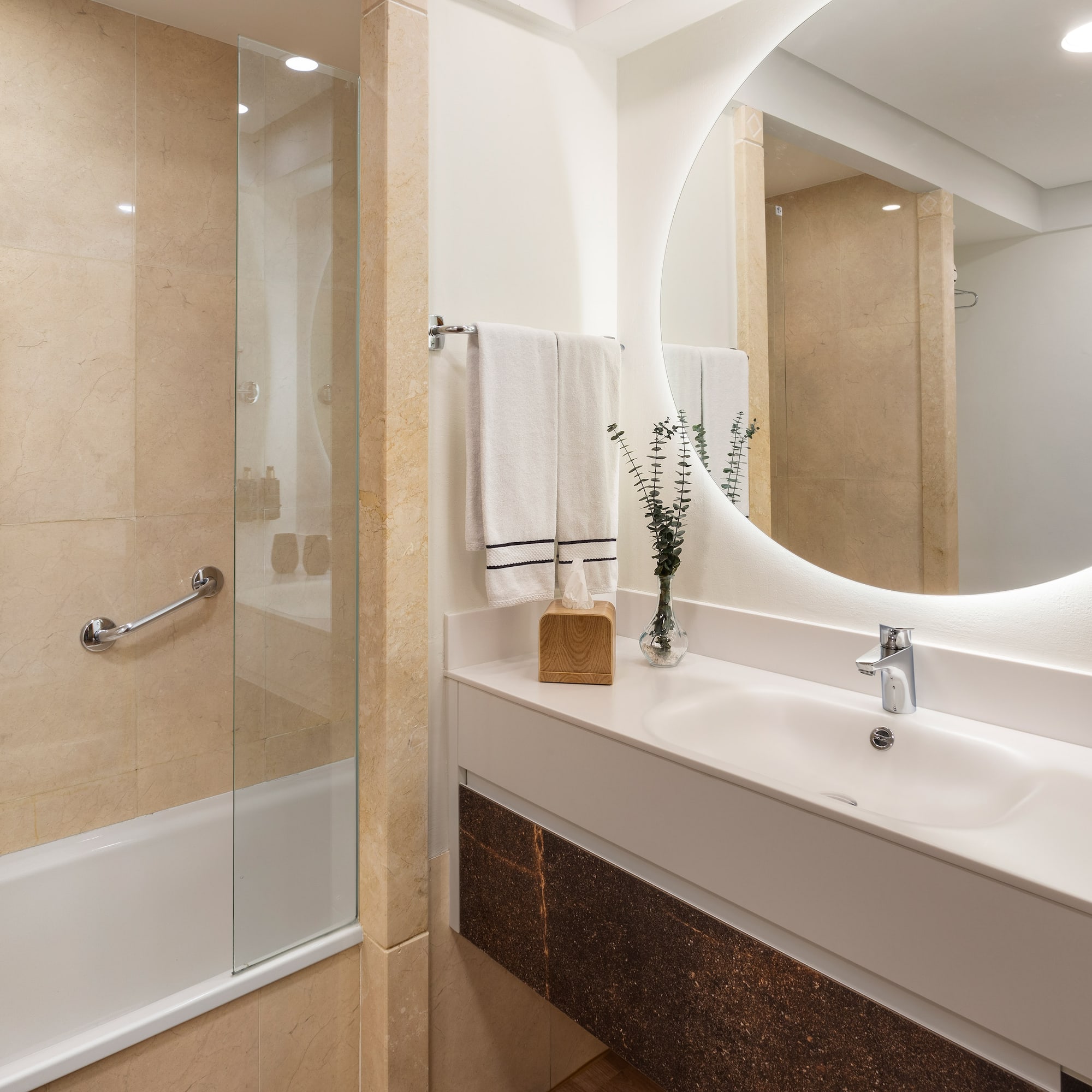 a bathroom with a round mirror and a shower