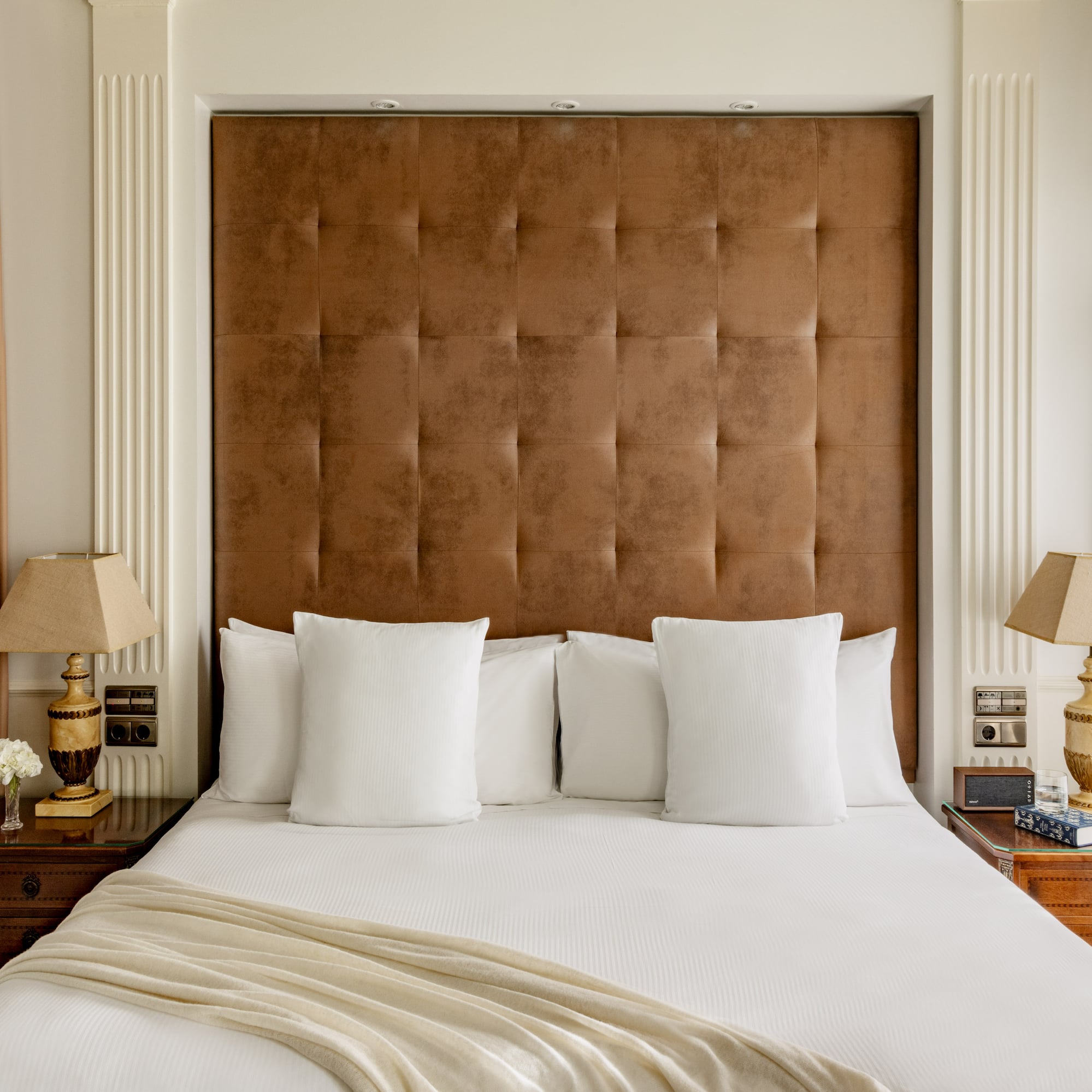 a bed with pillows and lamps in a room