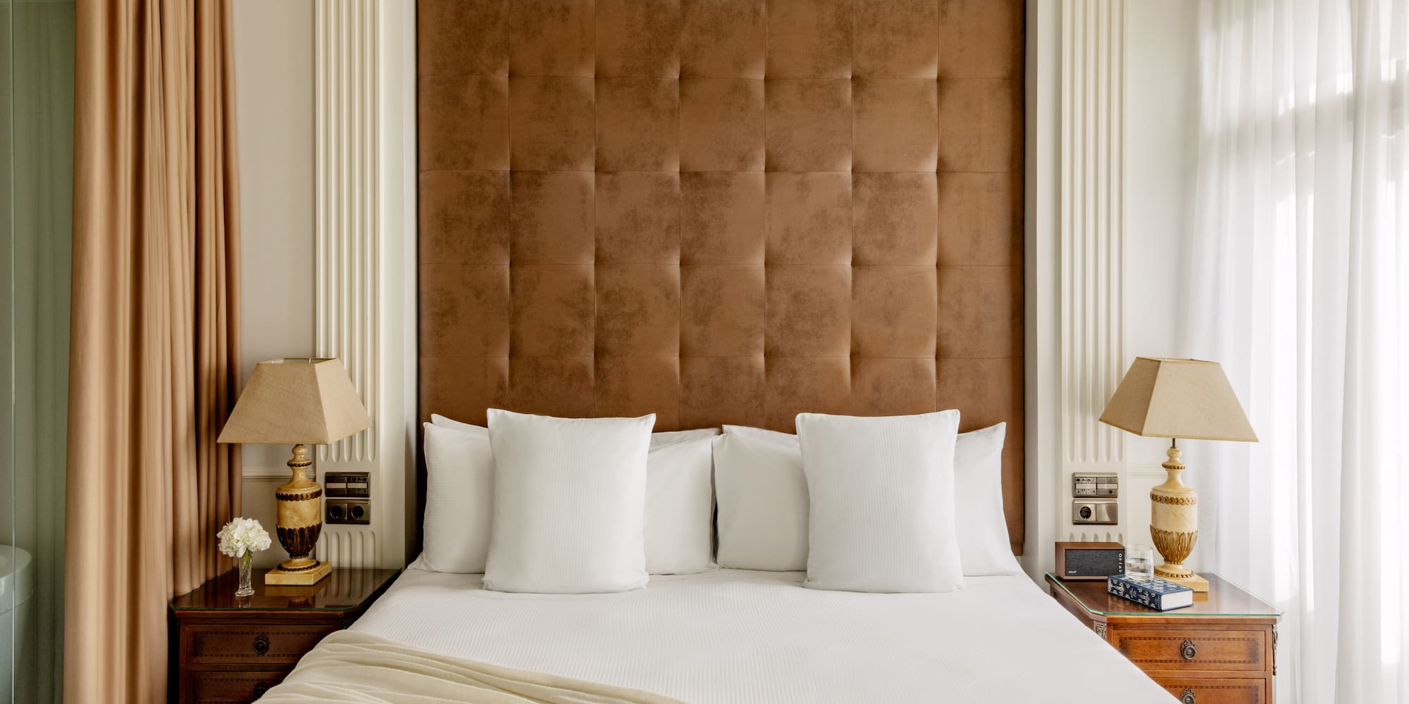 a bed with pillows and lamps in a room