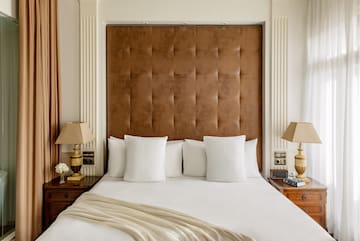 a bed with pillows and lamps in a room