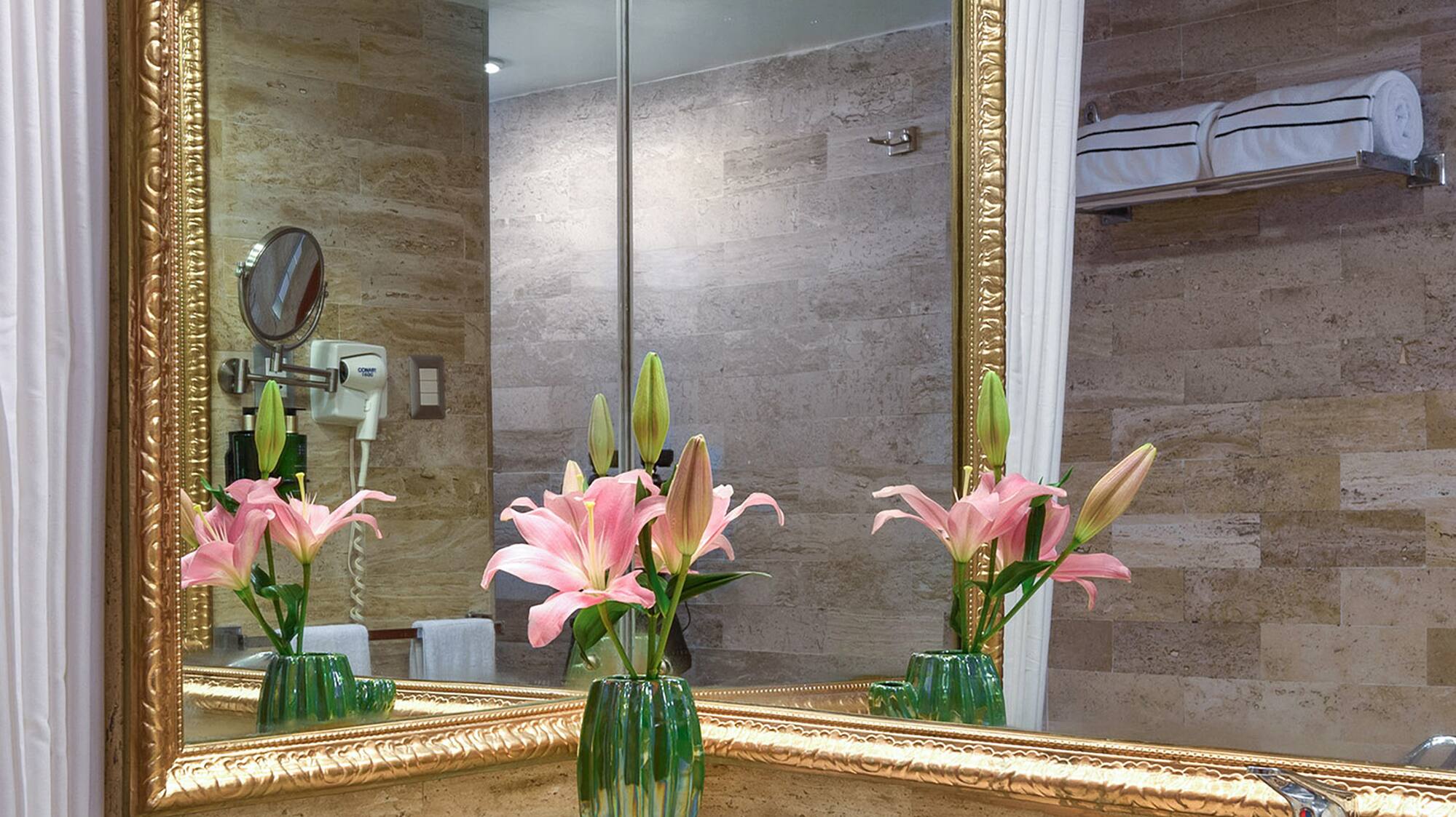 a bathroom with a mirror and flowers