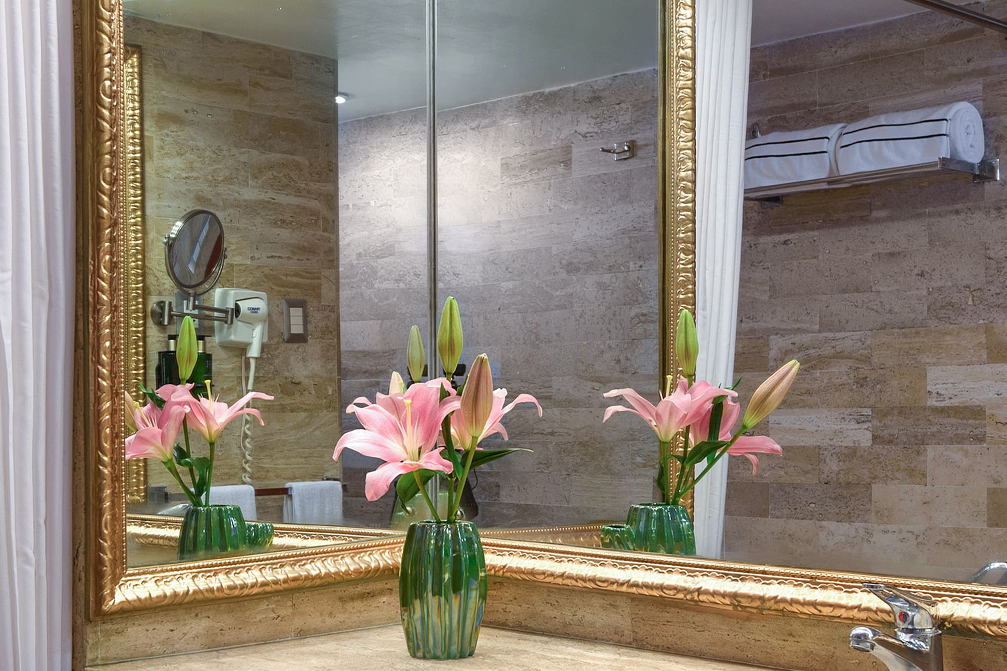 a bathroom with a mirror and flowers