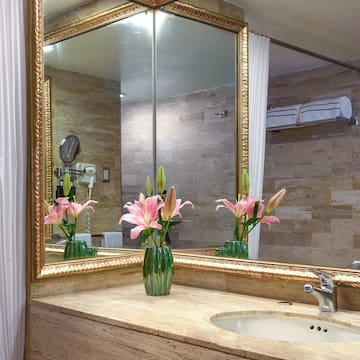 a bathroom with a mirror and flowers