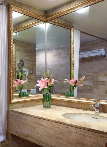 a bathroom with a mirror and flowers