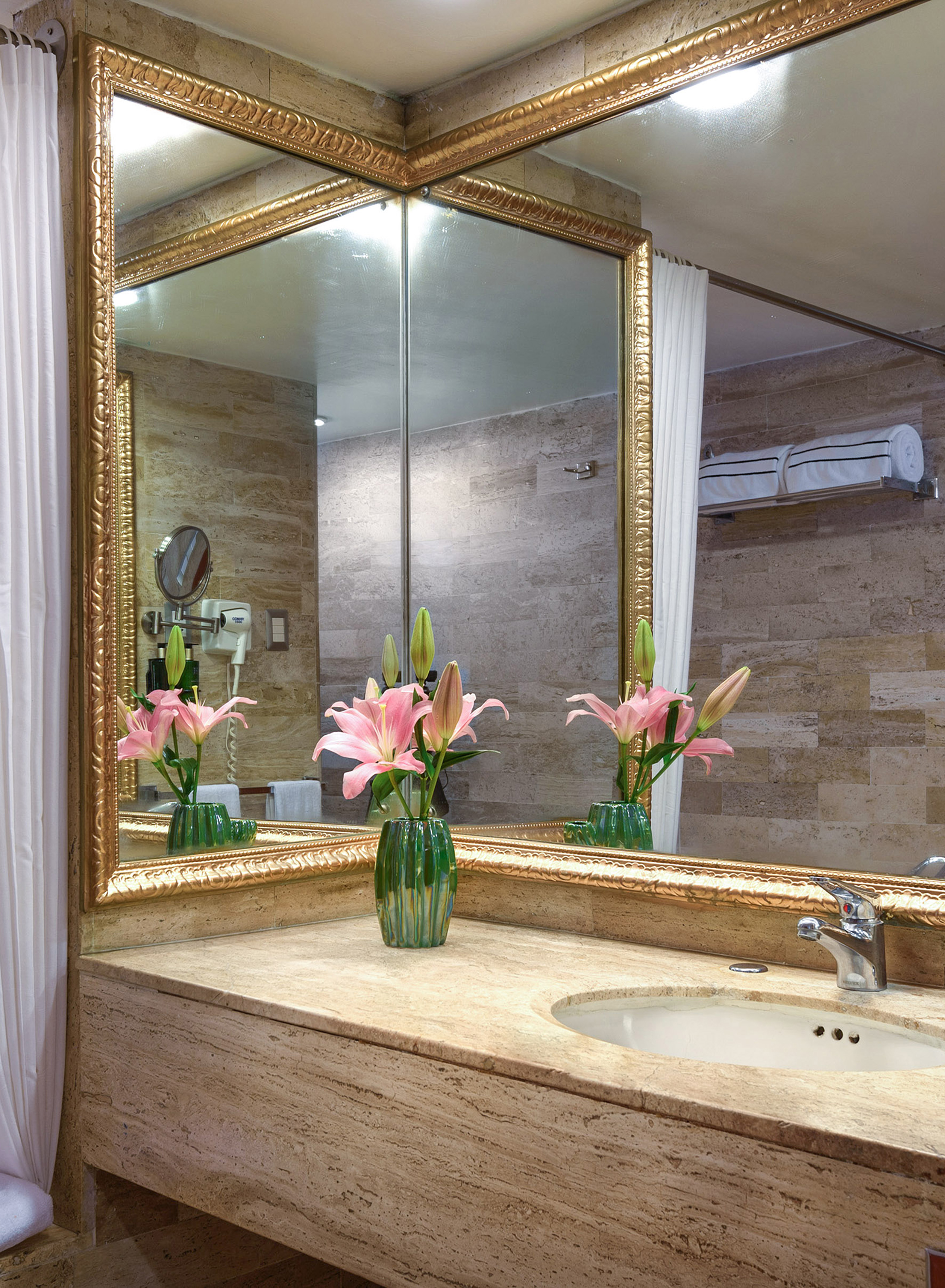 a bathroom with a mirror and flowers