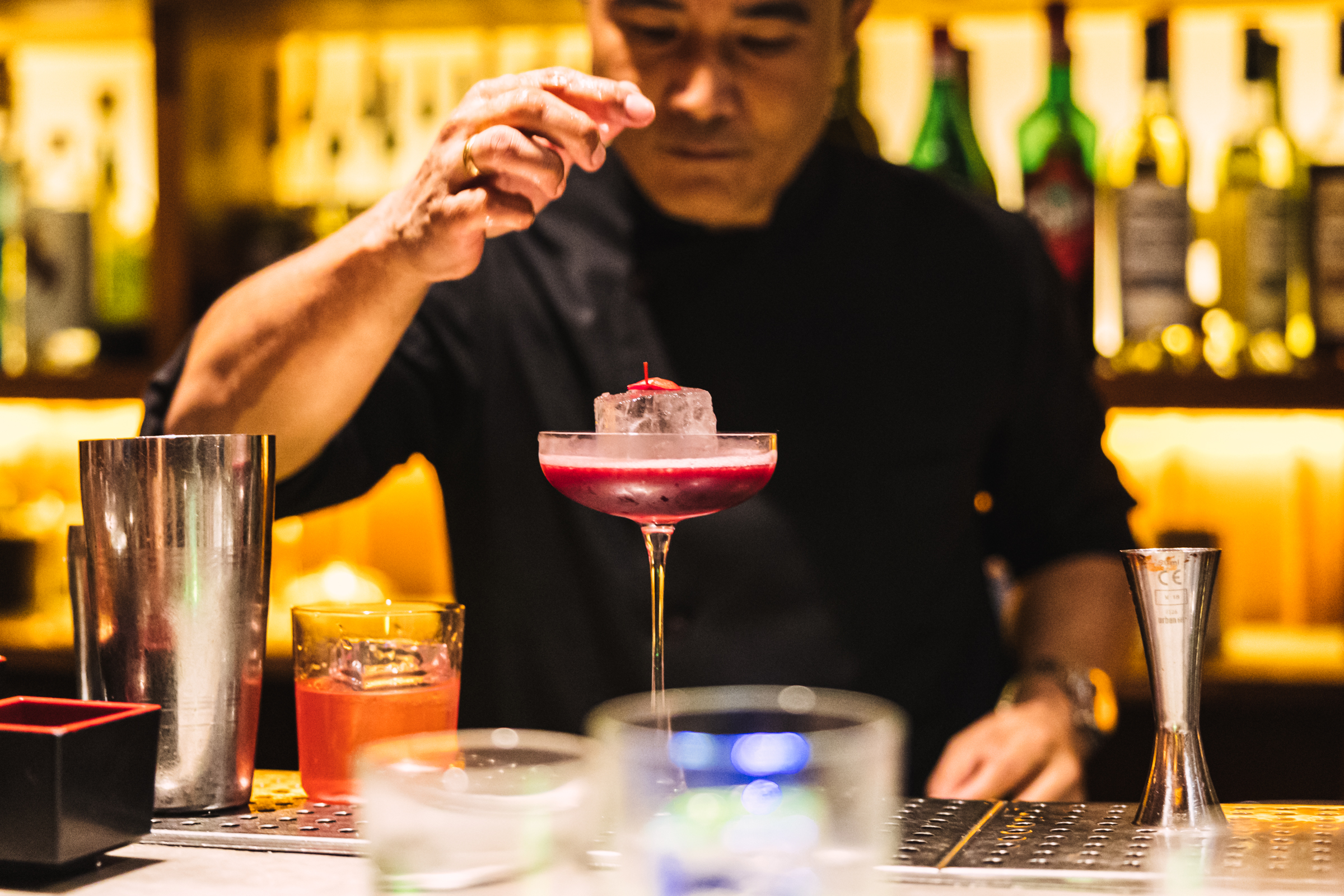 a man holding a piece of ice in a martini glass