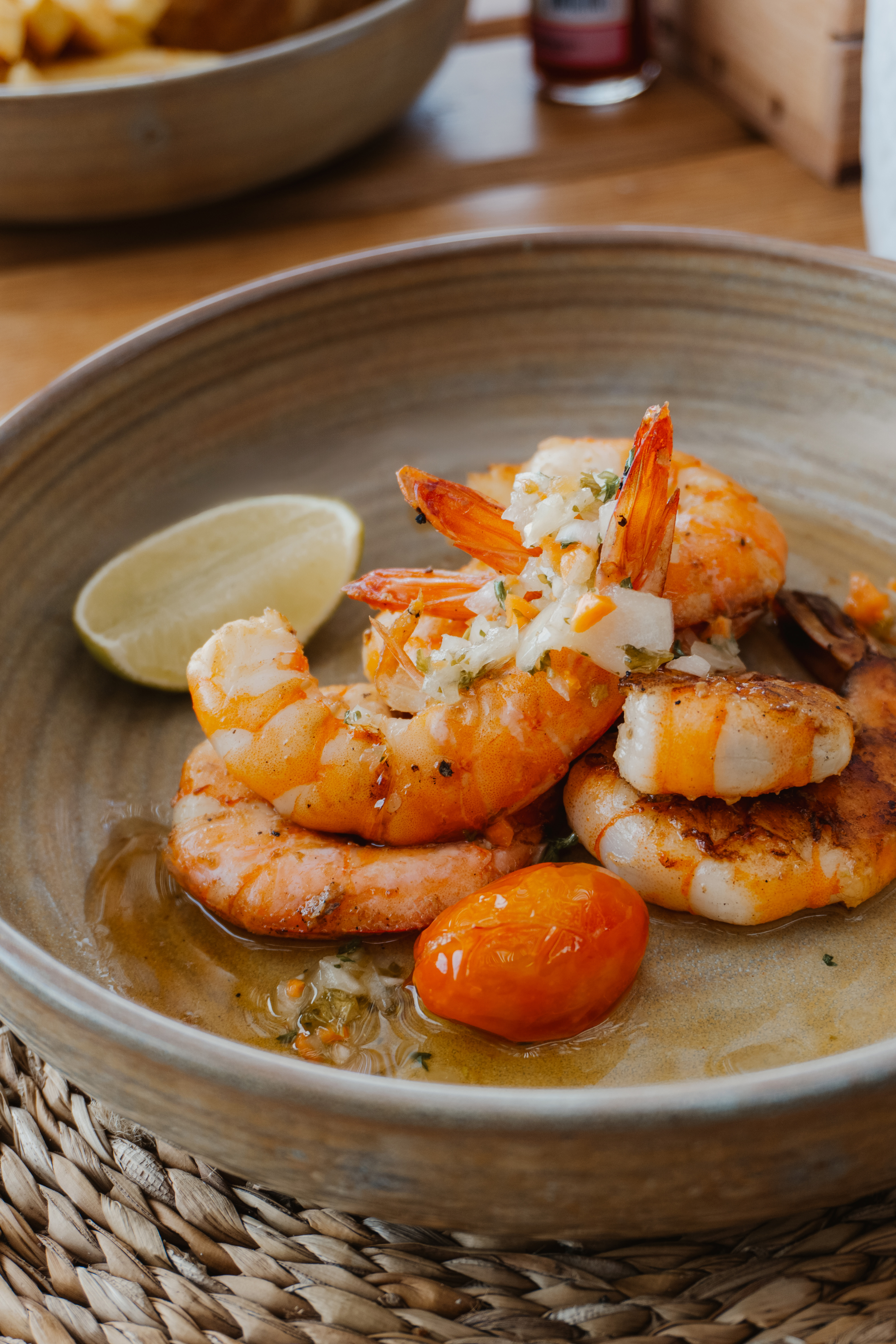 Sautéed shrimp with fresh salsa, lime wedge, and roasted tomatoes.