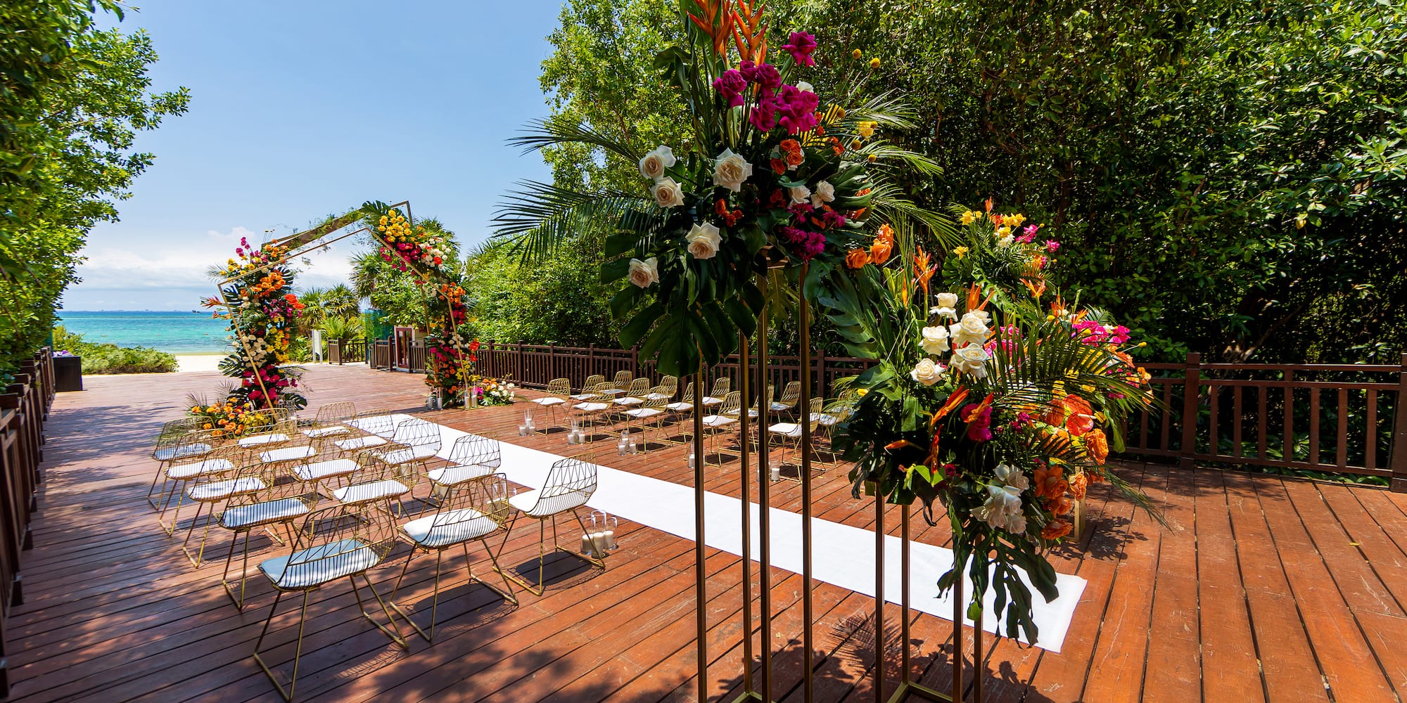 a group of chairs and flowers on a wooden deck