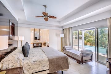 a bedroom with a bed and a pool in the background