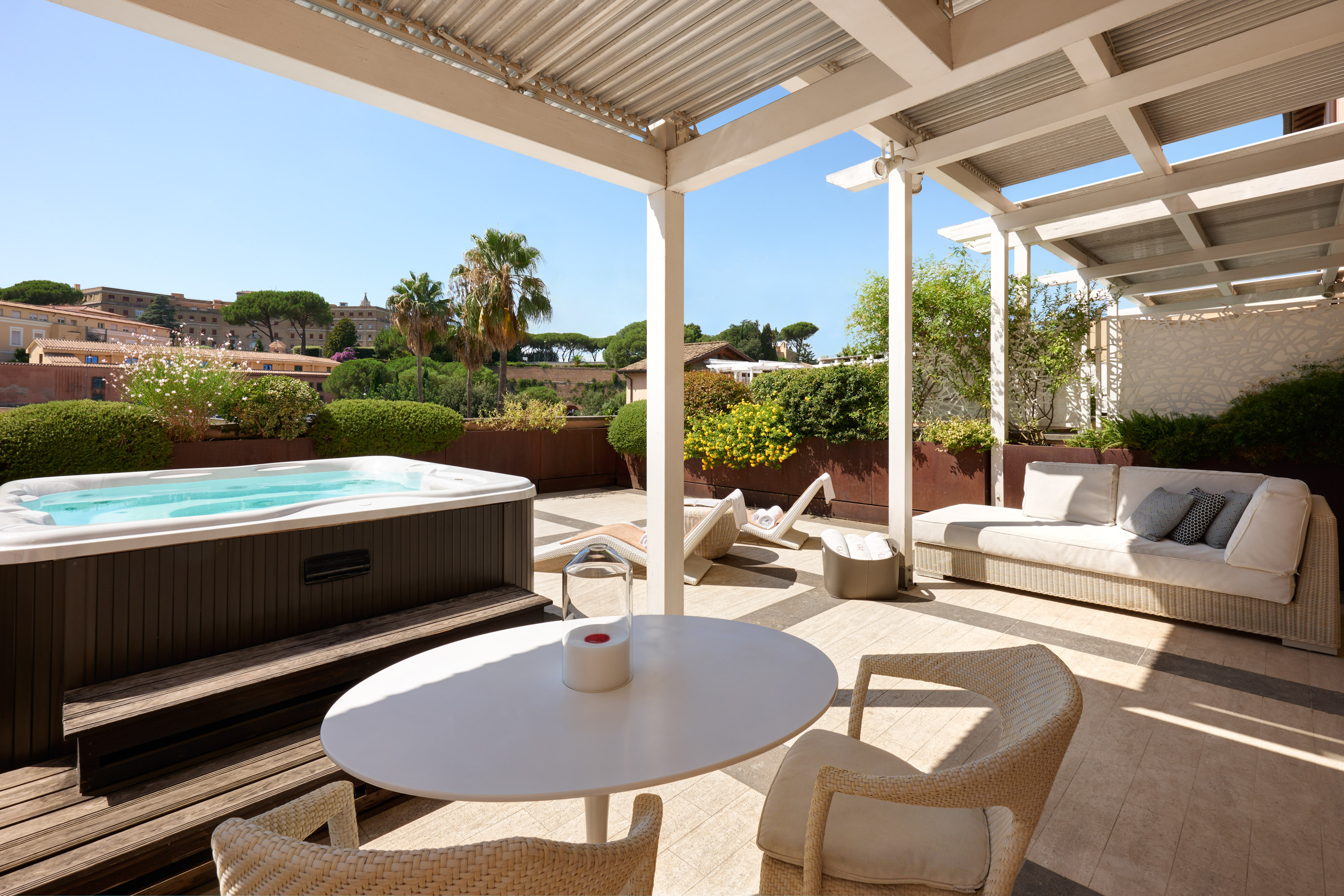 Rooftop terrace with hot tub, outdoor lounge seating, and city view.