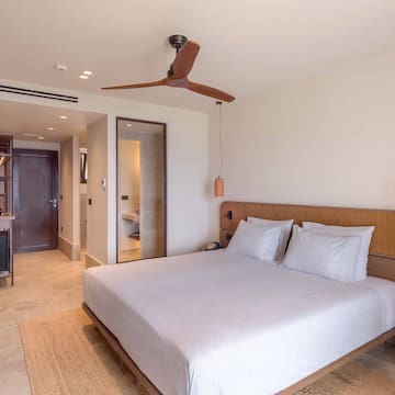 a bed with a wooden headboard and a ceiling fan