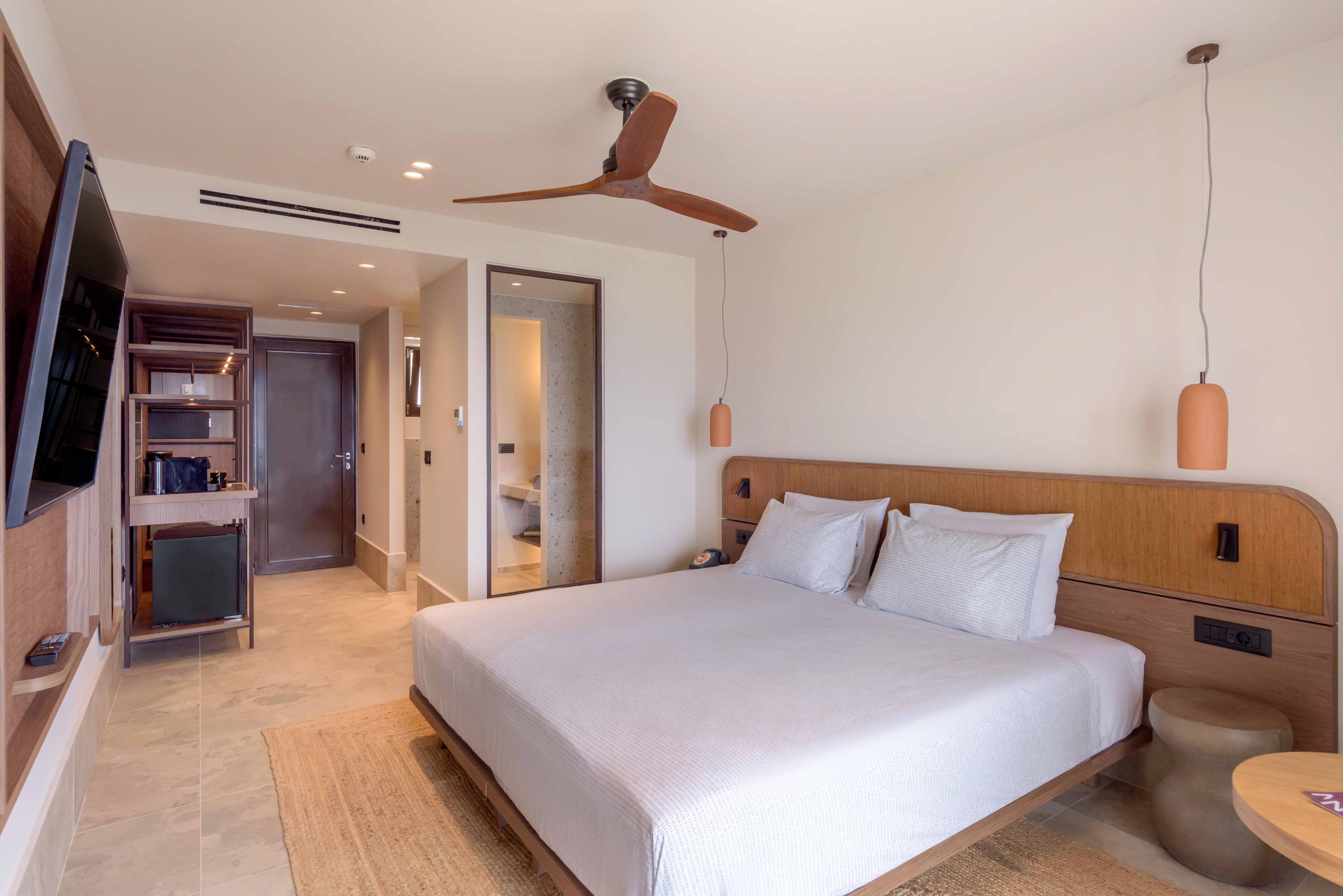 a bed with a wooden headboard and a ceiling fan