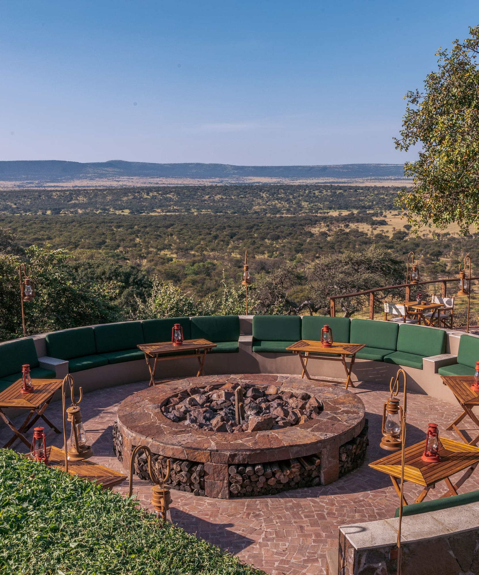 a fire pit with tables and chairs around it