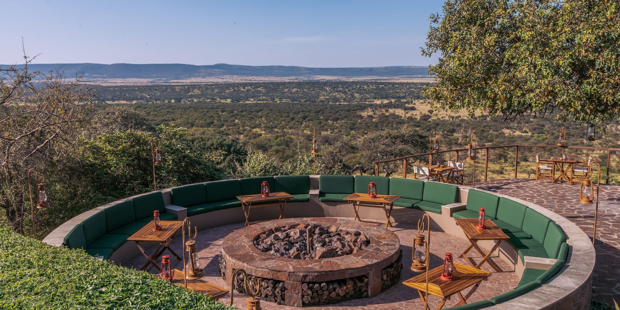 a fire pit with tables and chairs around it
