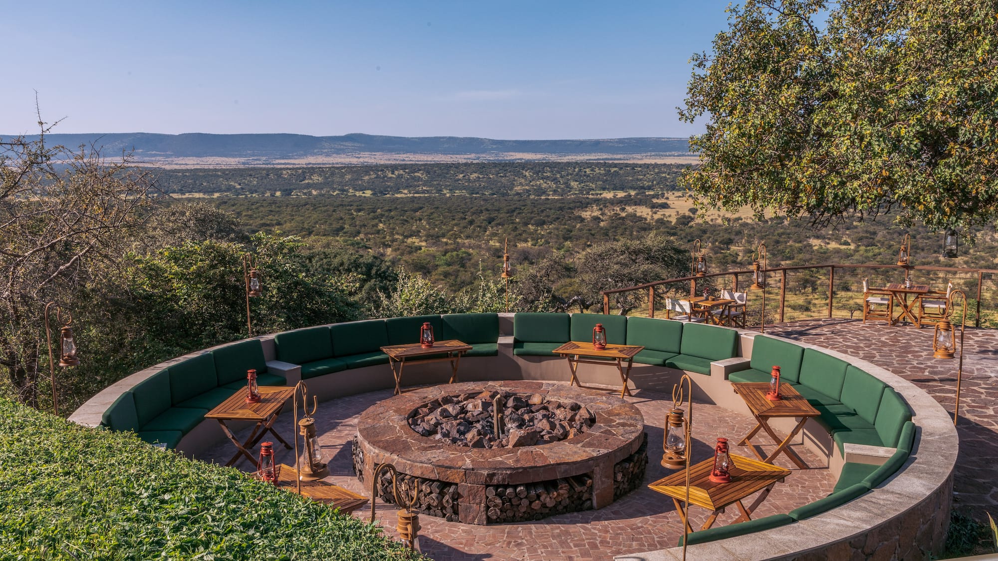a fire pit with tables and chairs around it