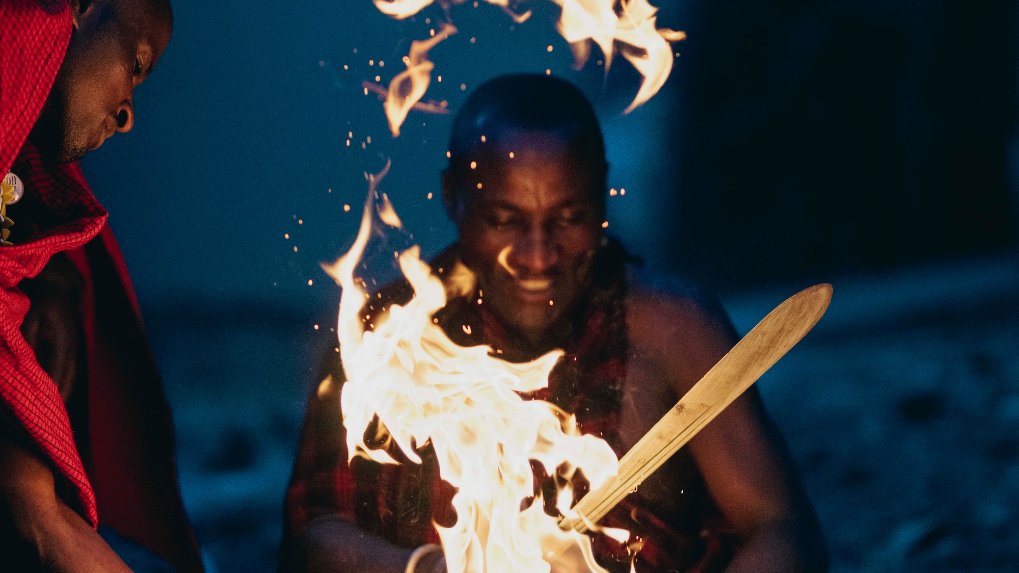 a group of men sitting around a fire