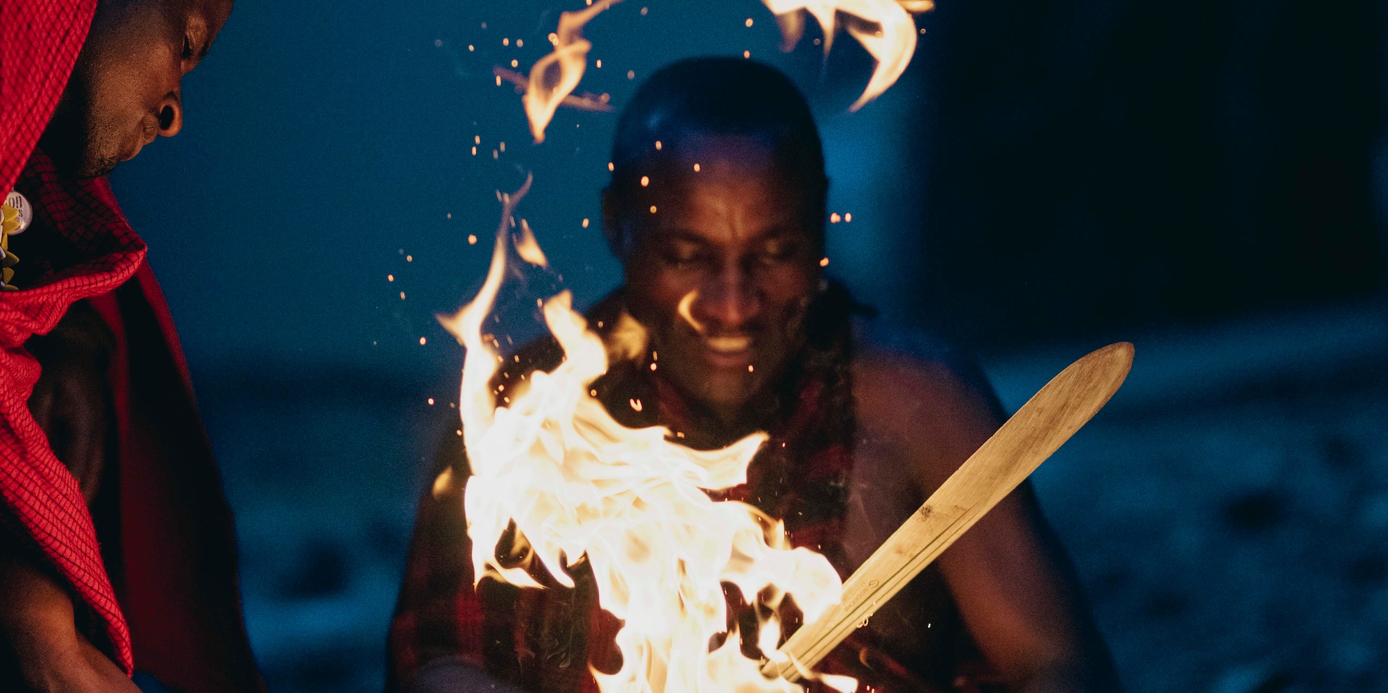 a group of men sitting around a fire