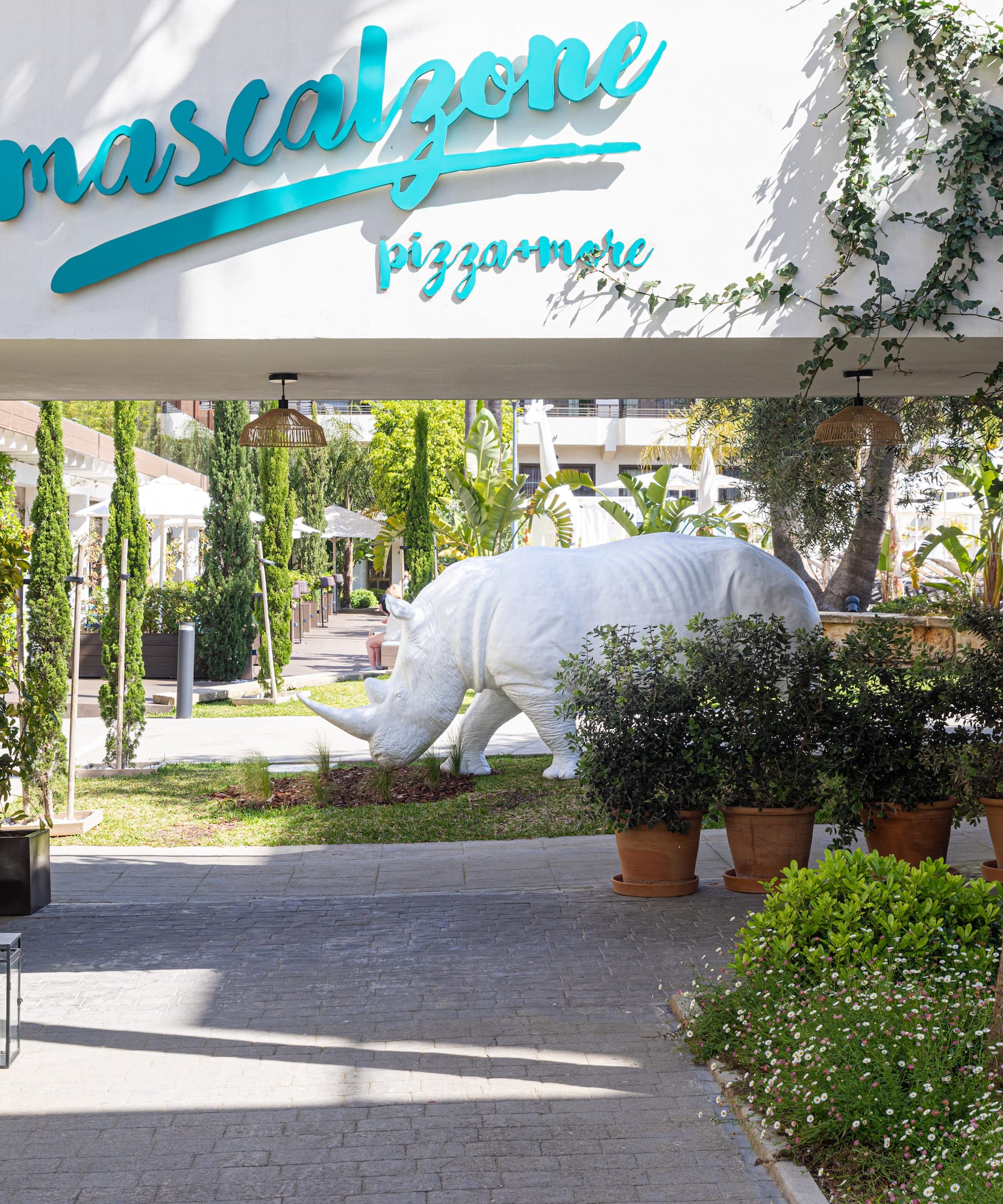 a white rhino statue under a white sign