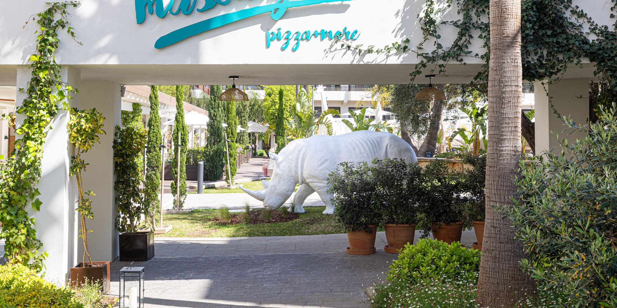 a white rhino statue under a white sign