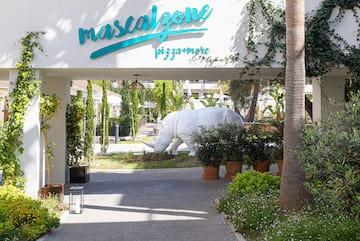 a white rhino statue under a white sign