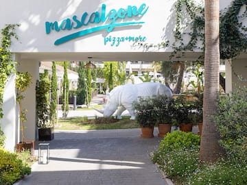 a white rhino statue under a white sign