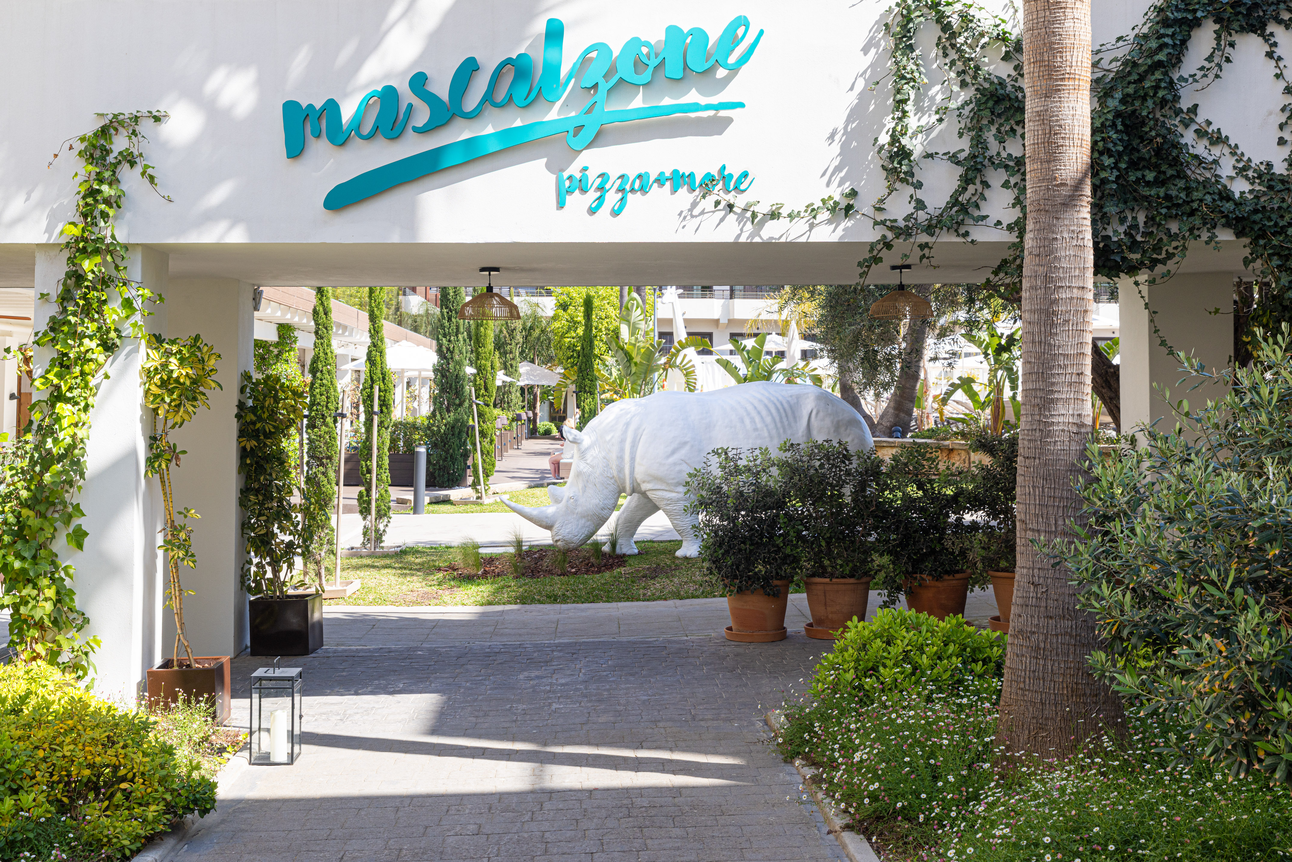 a white rhino statue under a white sign