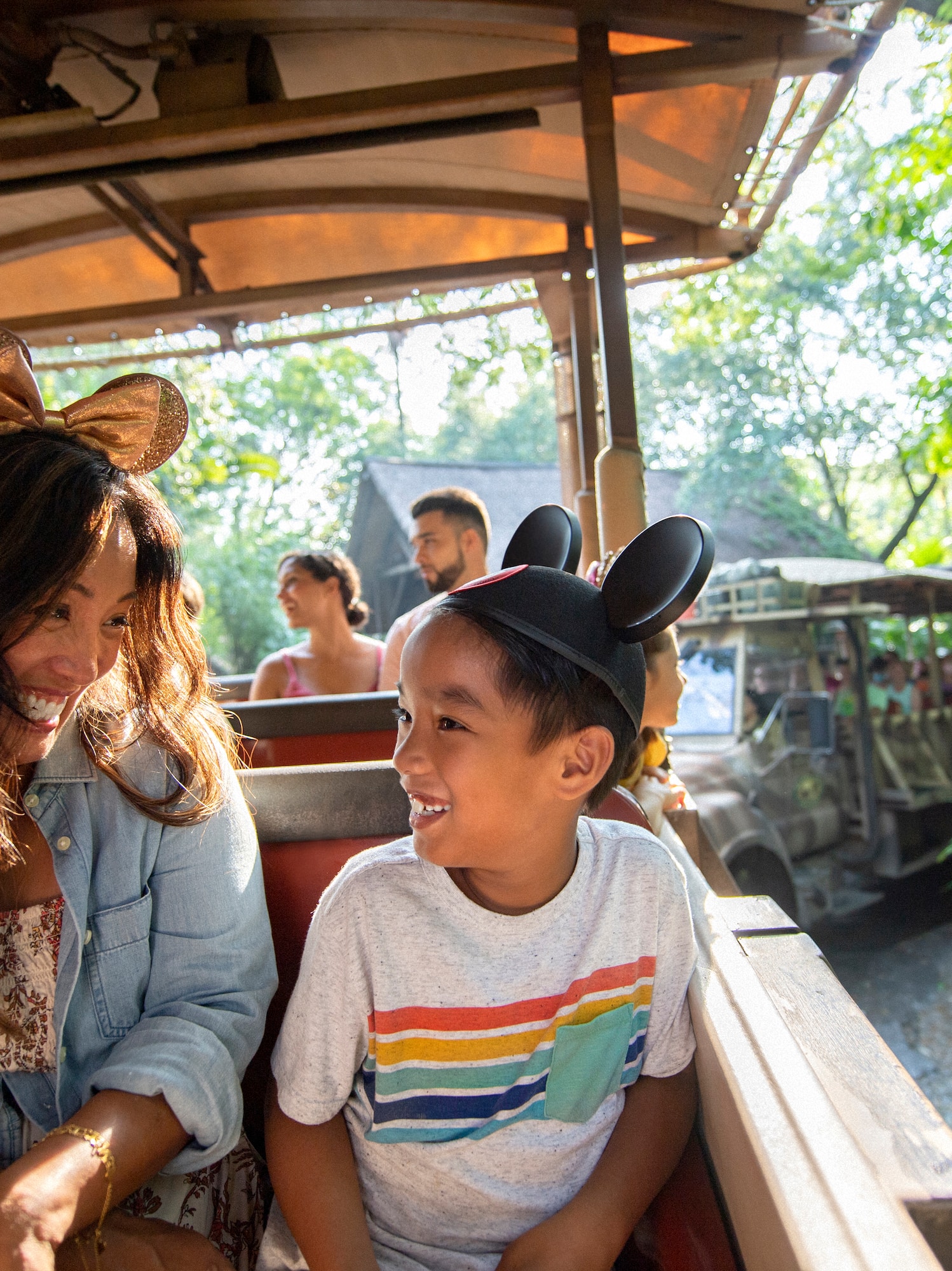 Smiling mother and son in Mickey ears on a Disney safari ride.