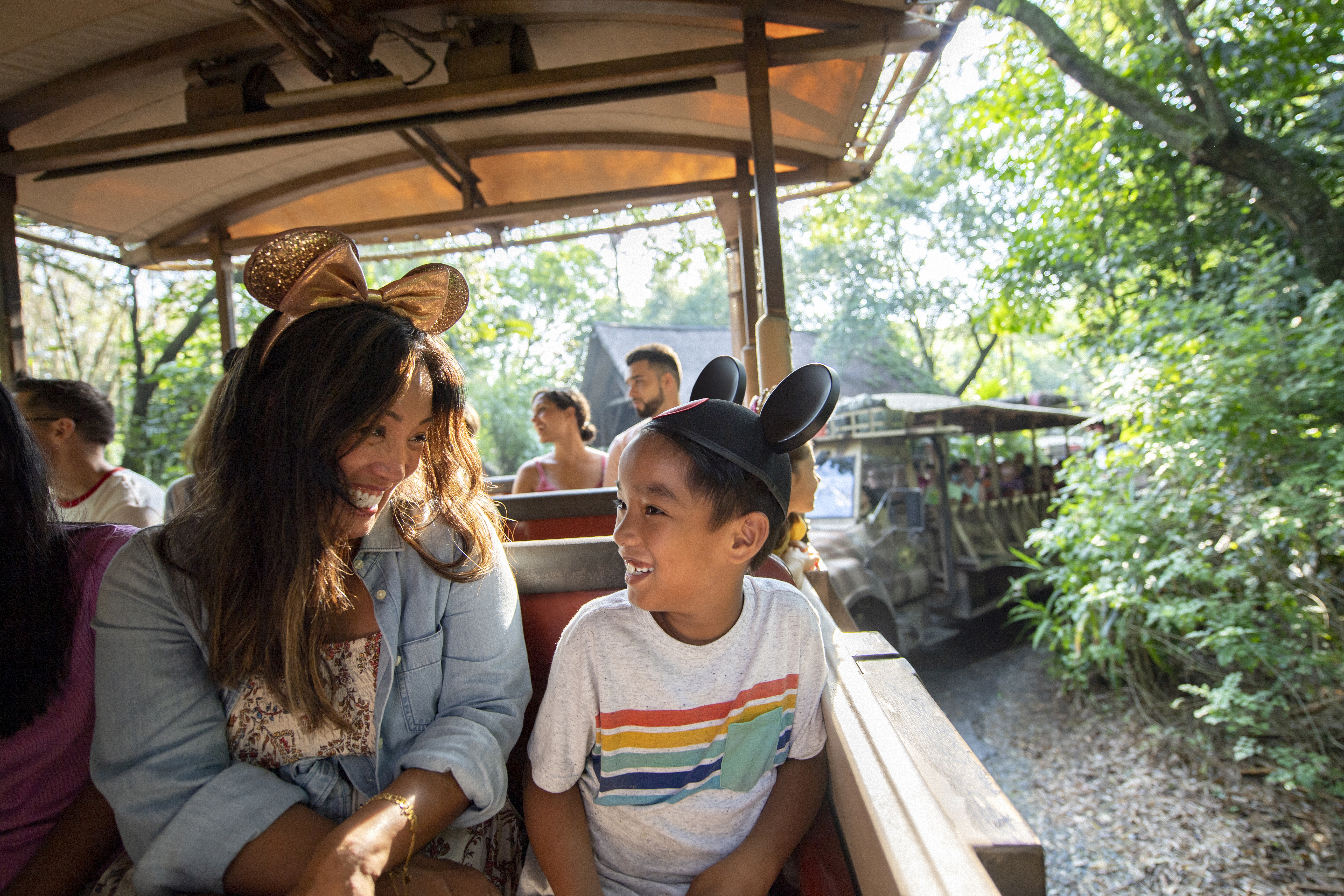 Smiling mother and son in Mickey ears on a Disney safari ride.