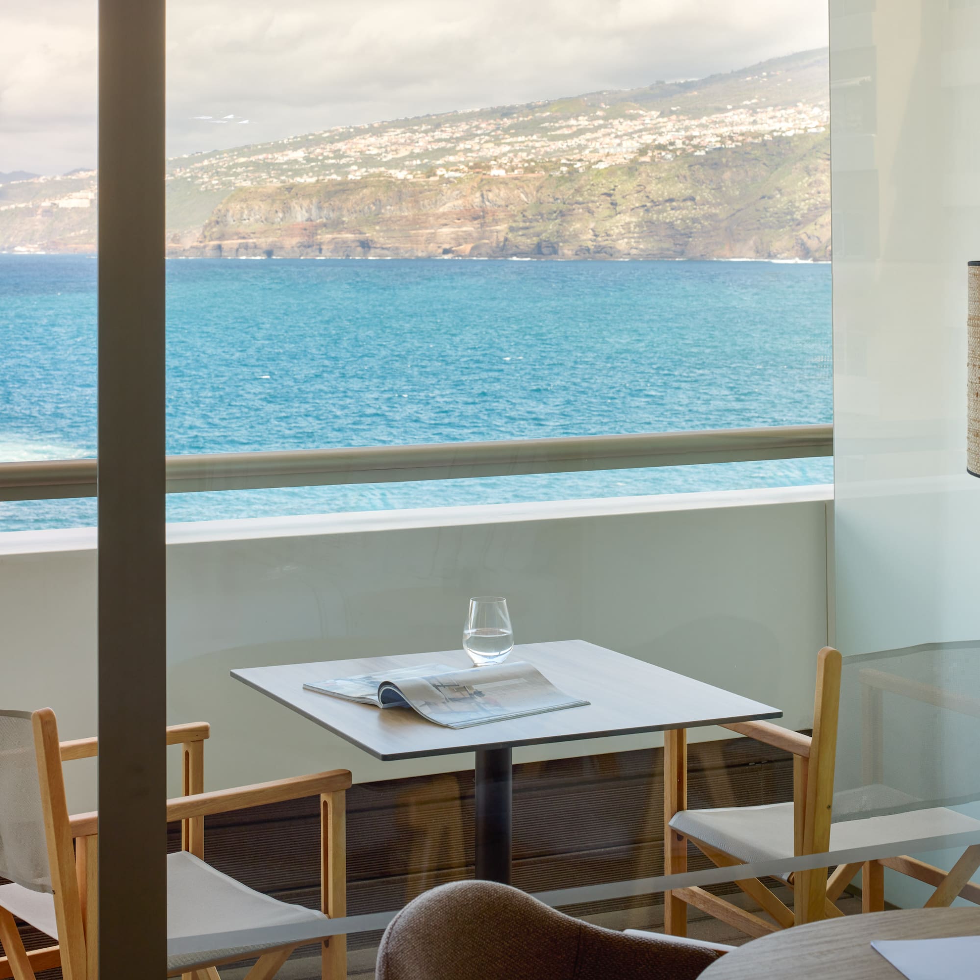 a table and chairs with a view of the ocean