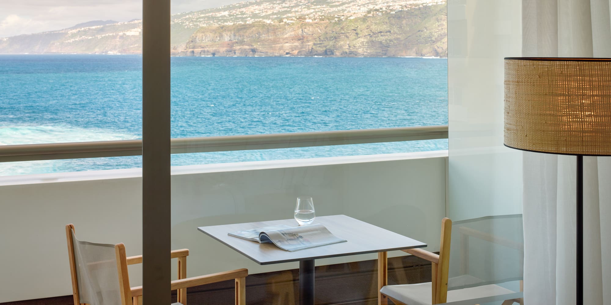 a table and chairs with a view of the ocean