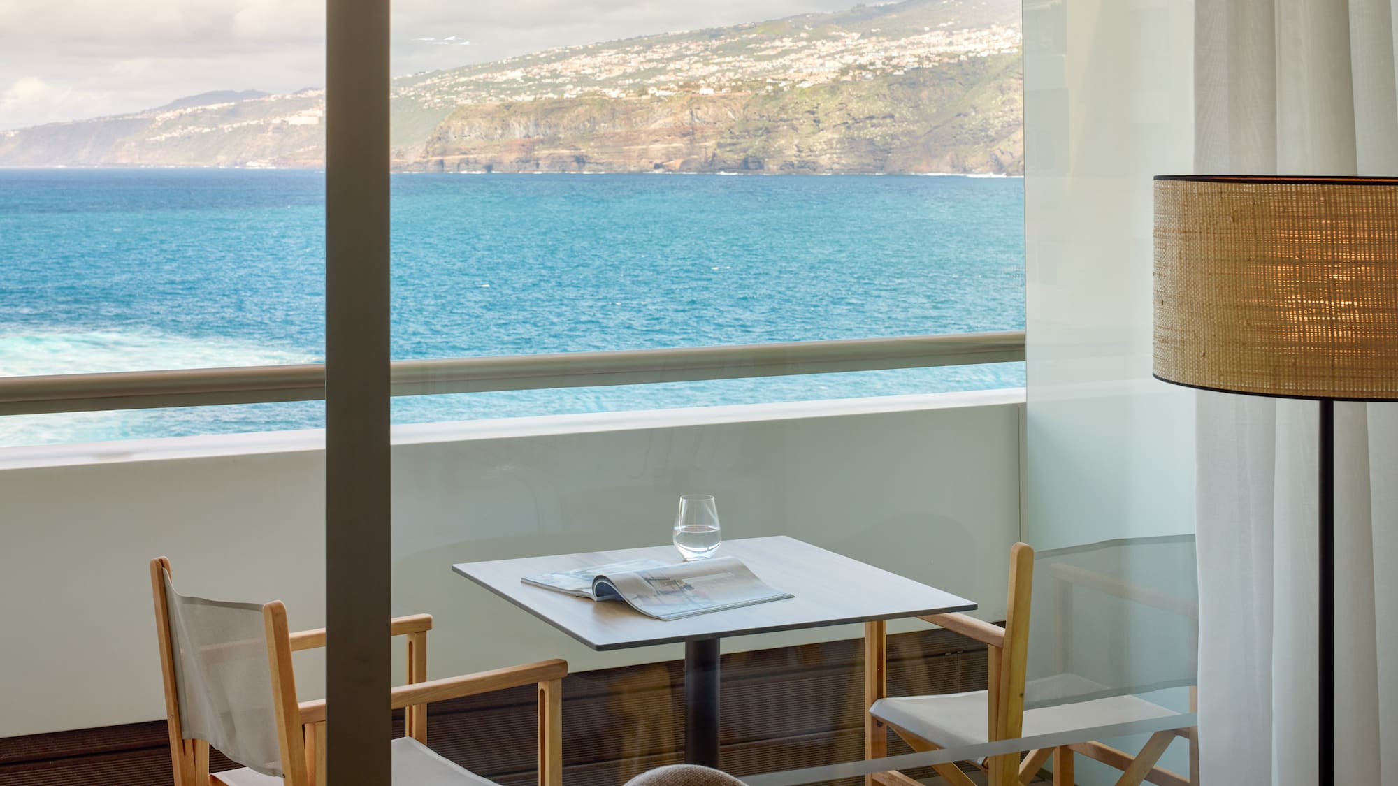a table and chairs with a view of the ocean