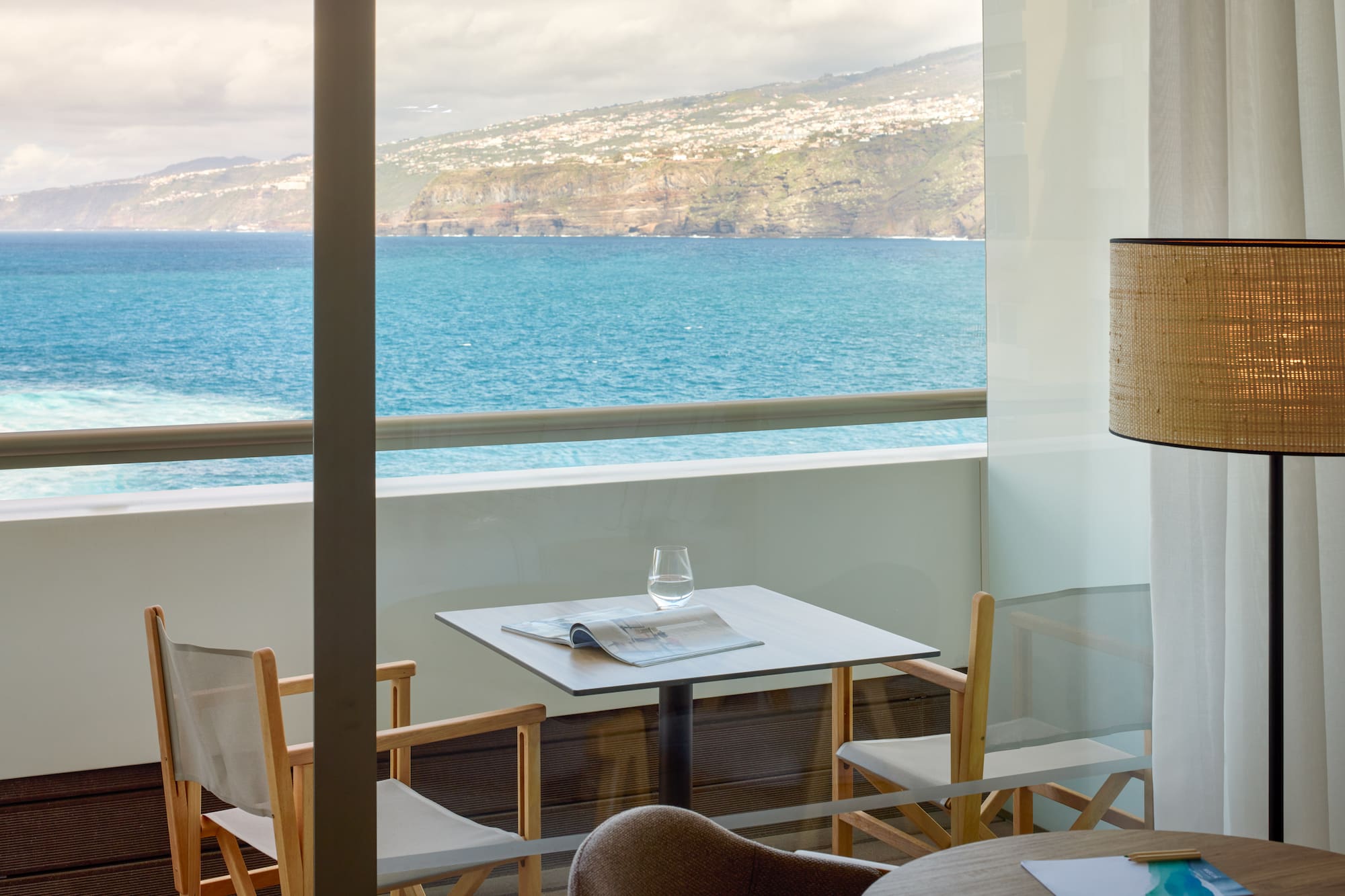 a table and chairs with a view of the ocean
