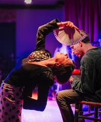 a woman holding a fan over a man's head