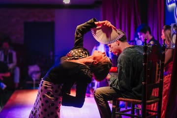 a woman holding a fan over a man's head