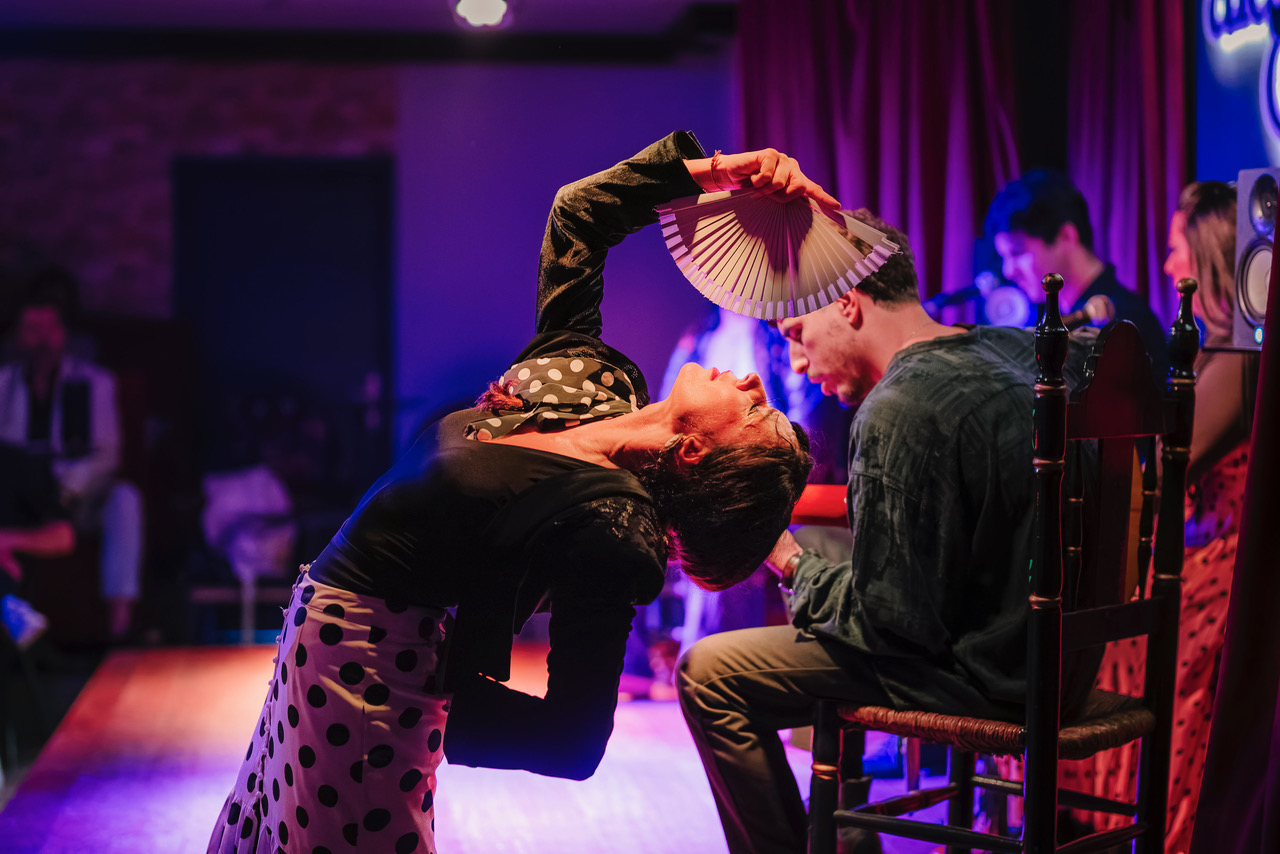 a woman holding a fan over a man's head