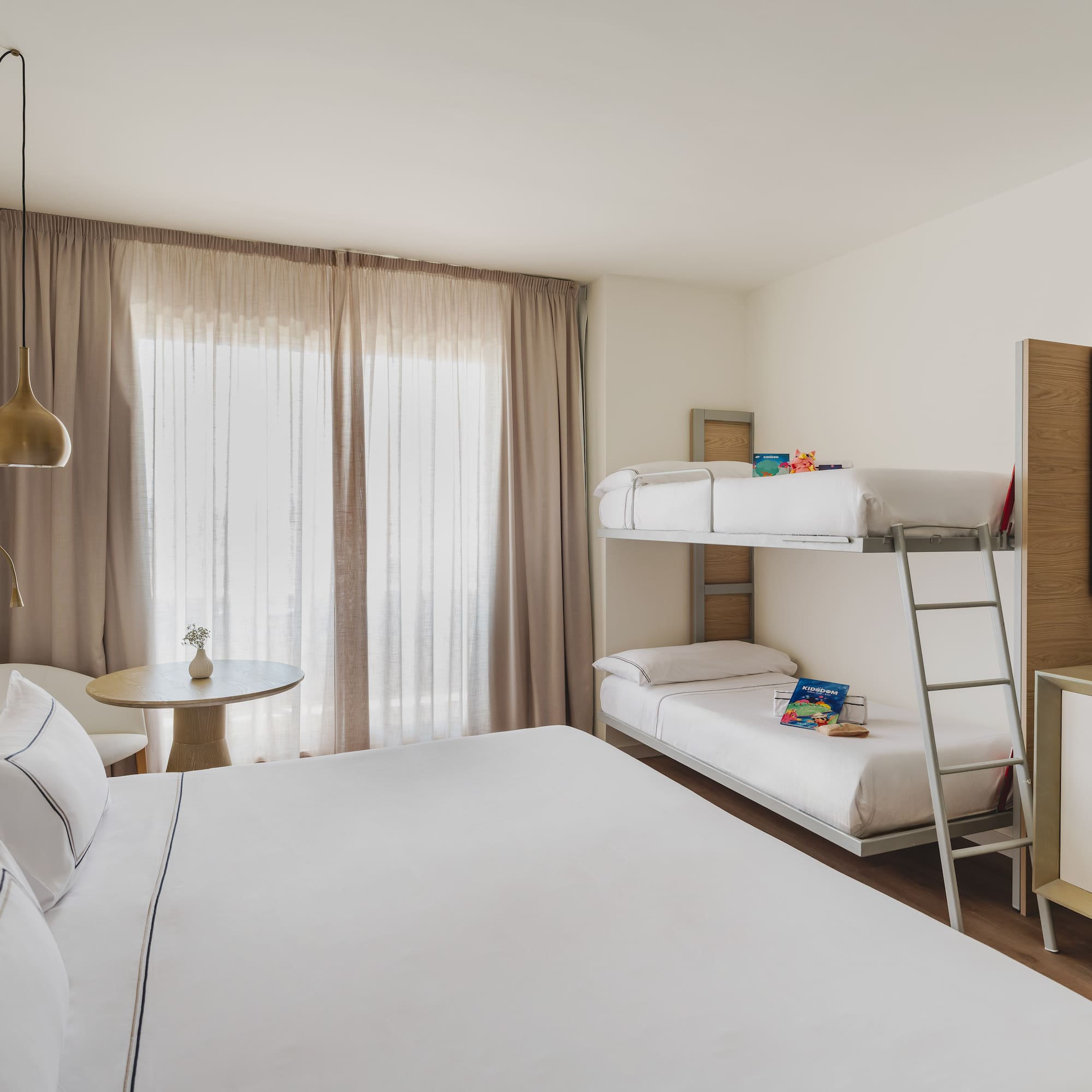 Habitación de hotel familiar moderna con cama doble y litera, ideal para vacaciones.