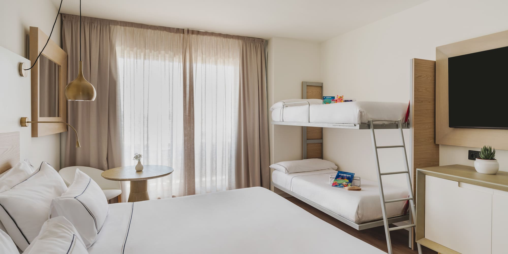 Habitación de hotel familiar moderna con cama doble y litera, ideal para vacaciones.