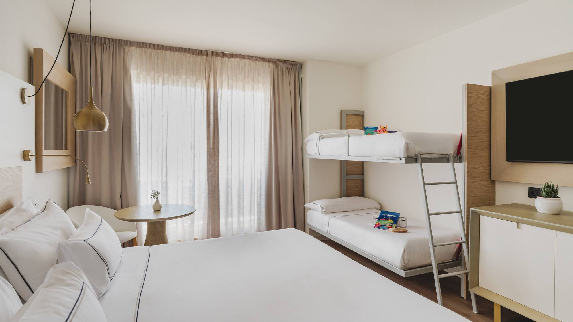 Habitación de hotel familiar moderna con cama doble y litera, ideal para vacaciones.