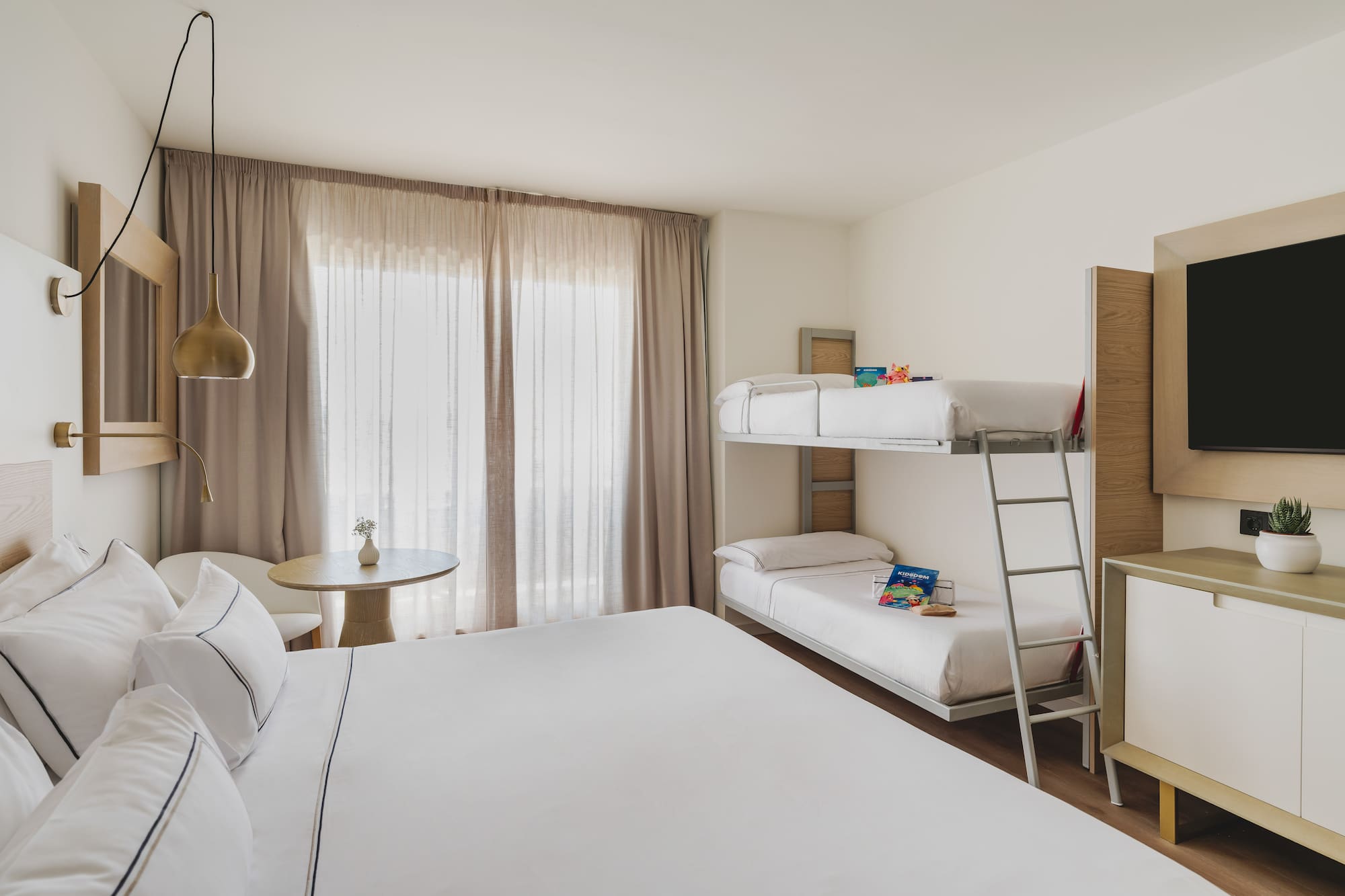 Habitación de hotel familiar moderna con cama doble y litera, ideal para vacaciones.