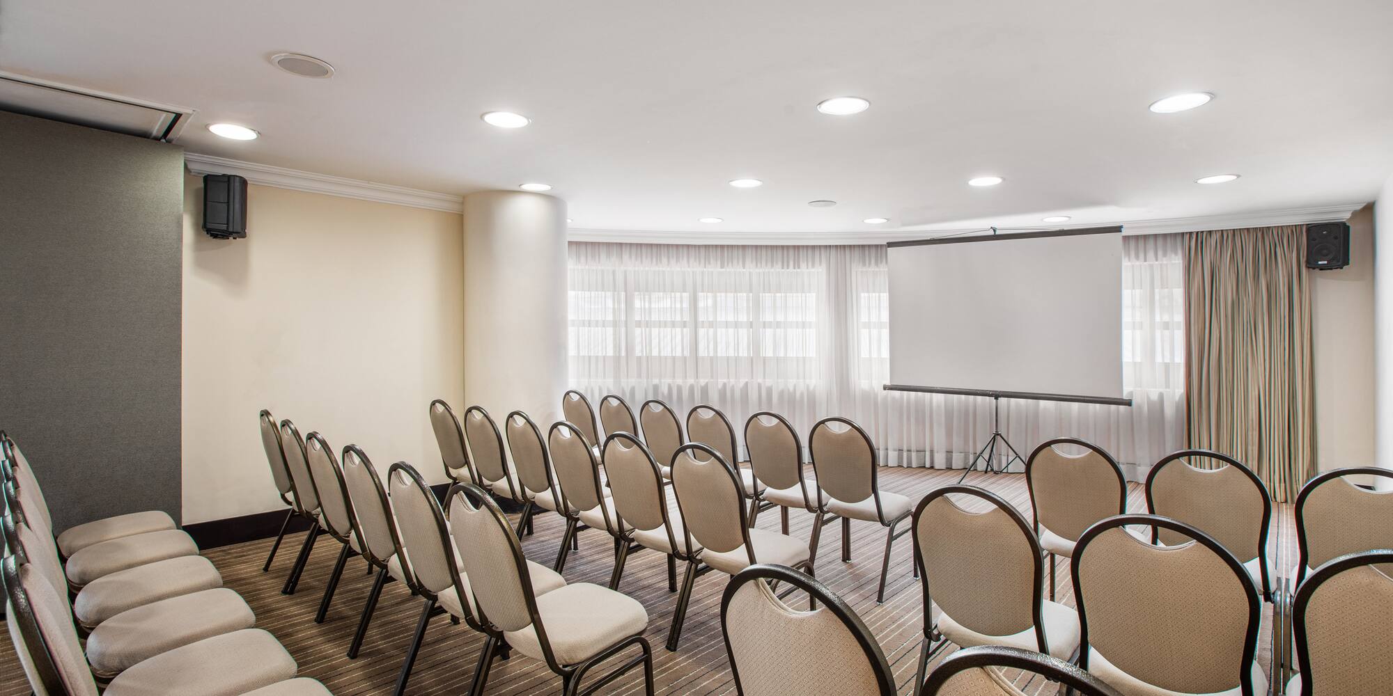 a room with chairs and a projector screen