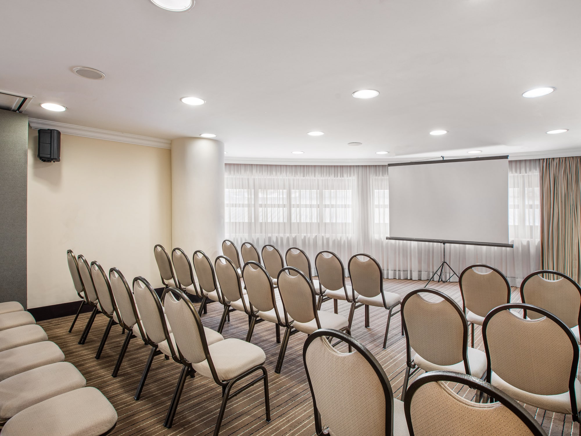 a room with chairs and a projector screen
