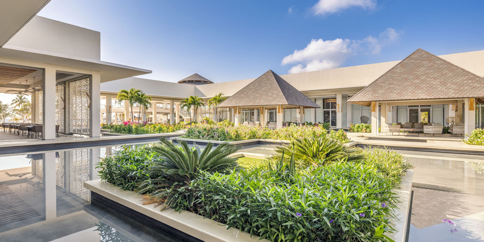 a building with a pool and plants