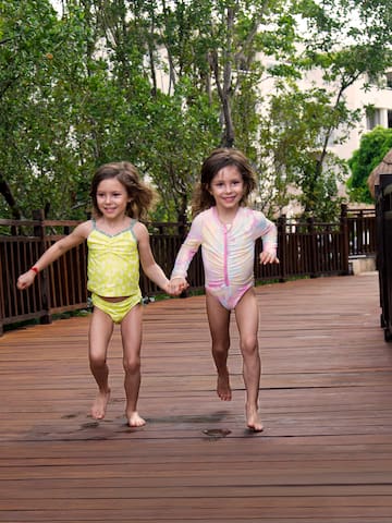 two girls running on a wooden walkway
