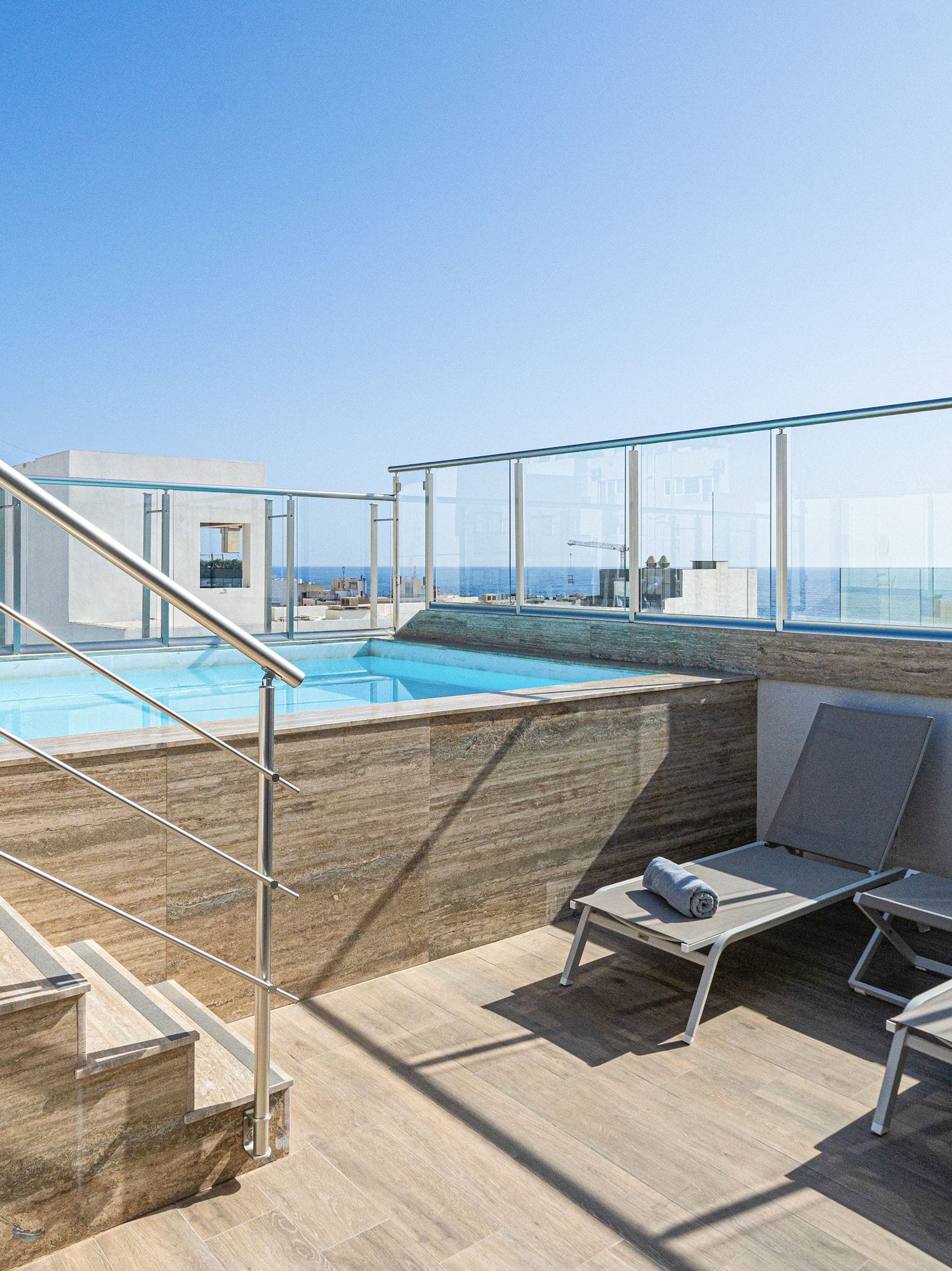 a pool with a deck chair and a railing