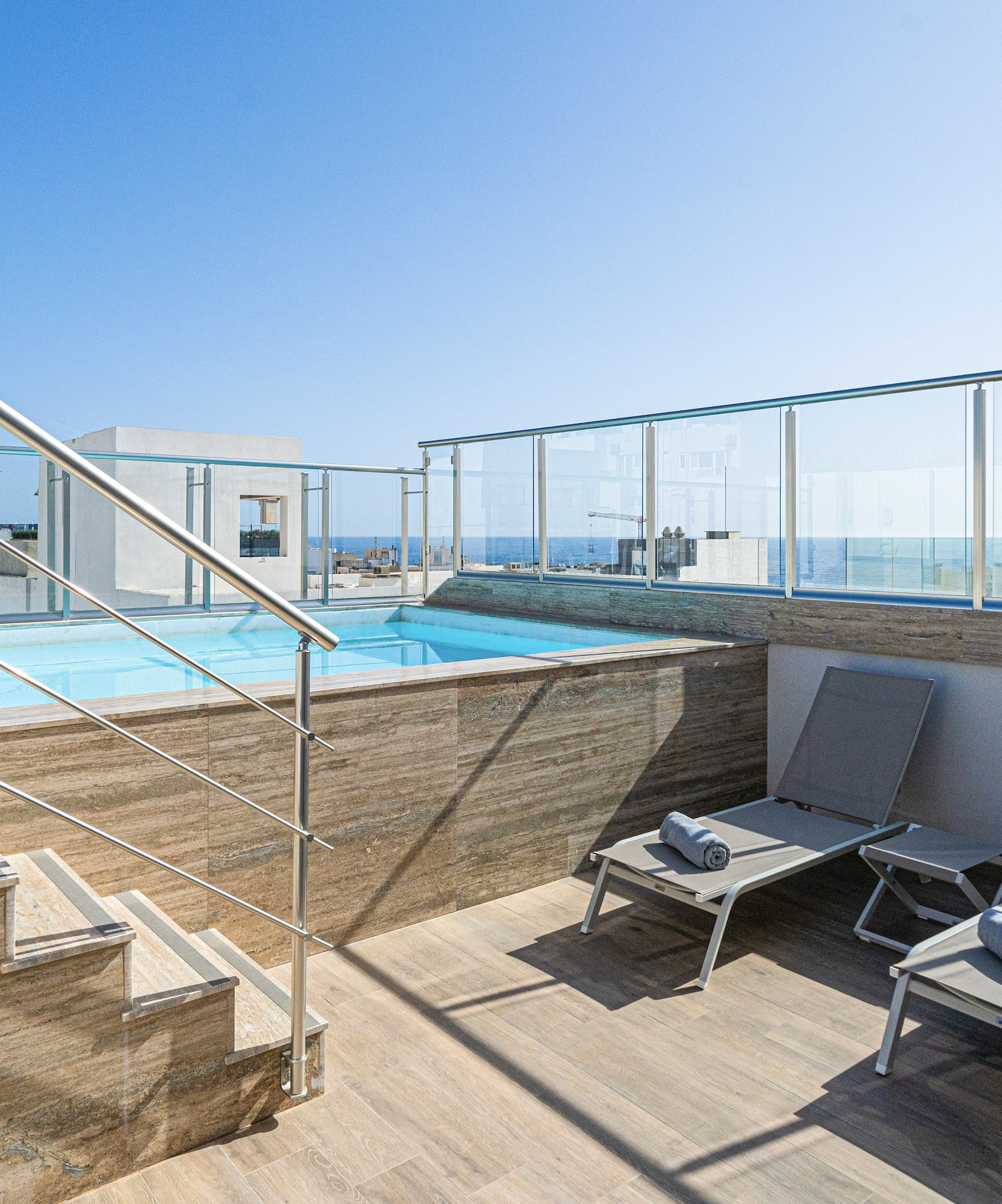 a pool with a deck chair and a railing