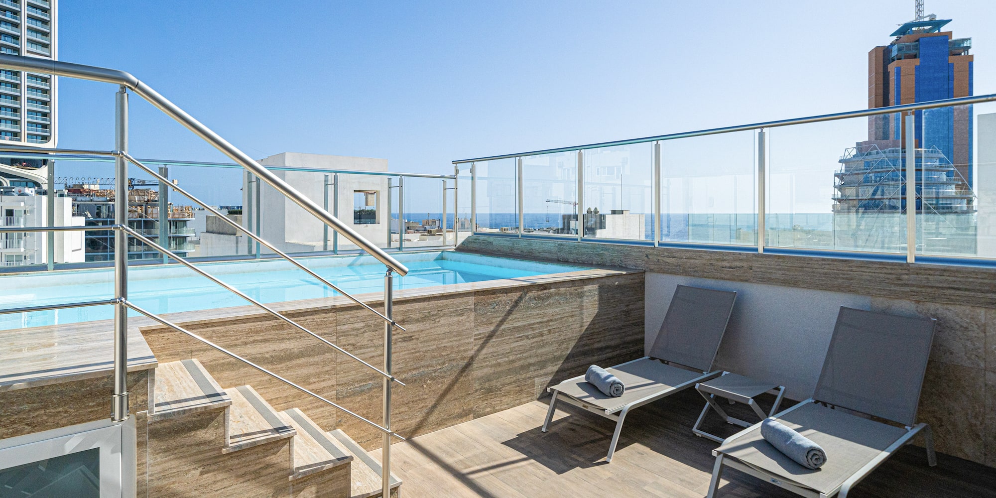 a pool with a deck chair and a railing
