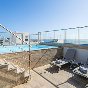a pool with a deck chair and a railing