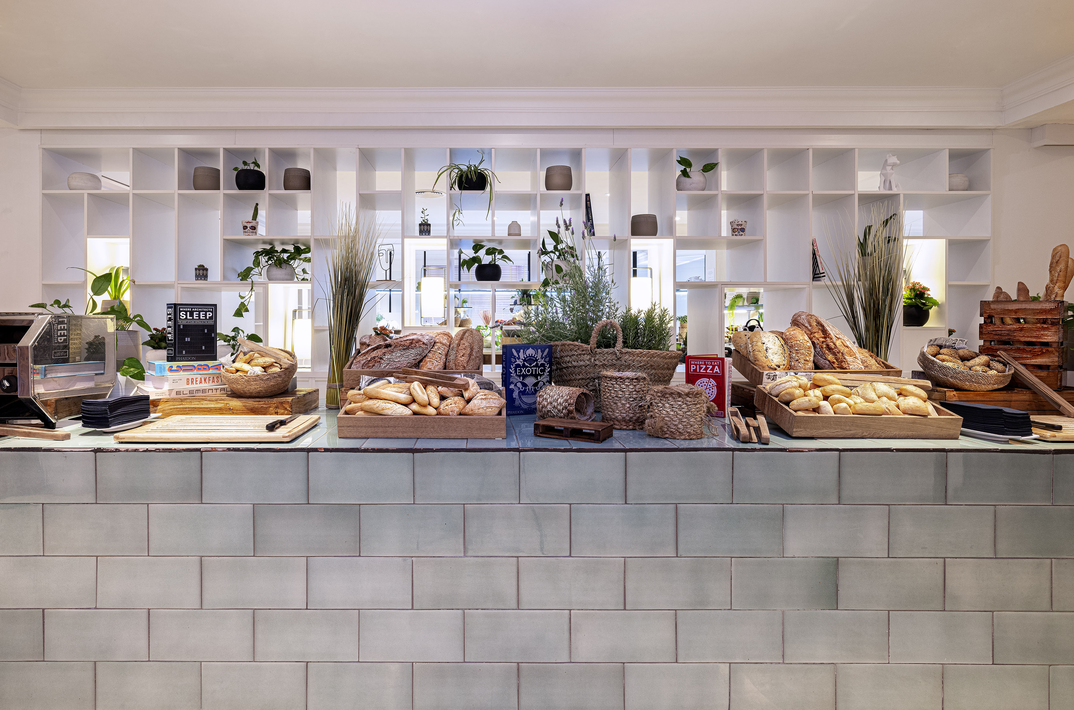 Fresh bread and rolls on a modern breakfast buffet display.