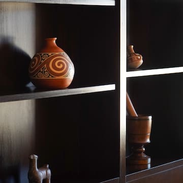 a shelf with a vase and mortar