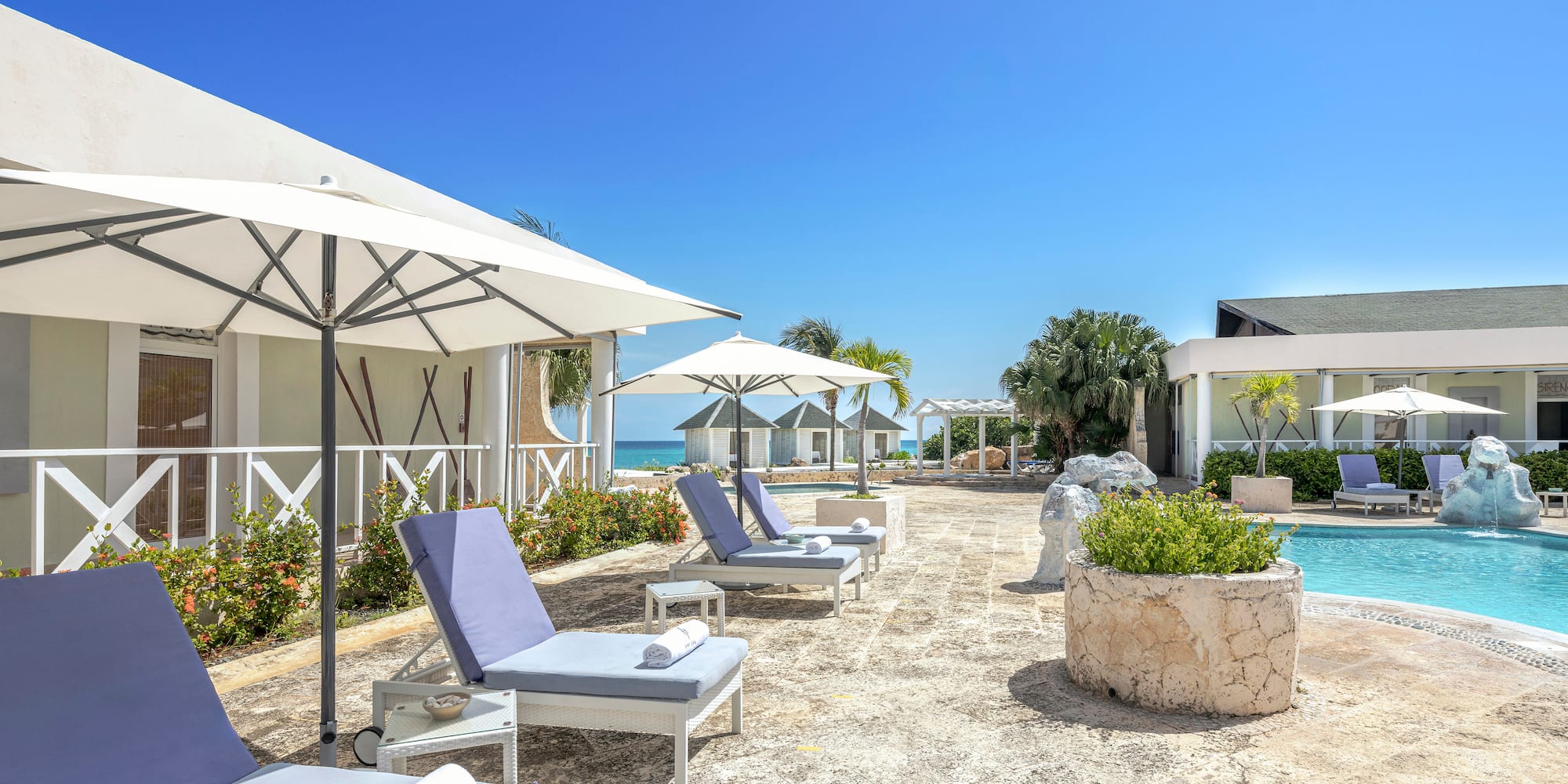 a pool with lounge chairs and umbrellas